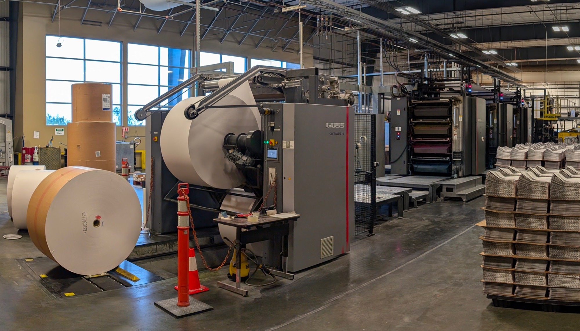 Community Impact Printing production floor in Pflugerville, Texas — GOSS press with paper rolls